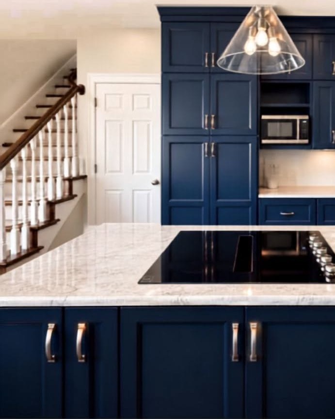 Taj Mahal quartzite island installed by Absolute Stone Design TN in a navy kitchen